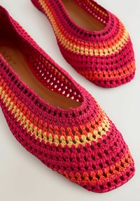 Patalones crochet dengan pola gradasi dalam warna merah muda, oranye, dan kuning. Ujung bulat dan tekstur anyaman terbuka dengan lapisan dalam yang halus.