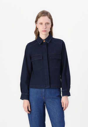 Giacca di jeans blu scuro con tasche sul petto, chiusura a bottoni e colletto classico; presenta maniche lunghe e un design leggermente corto.