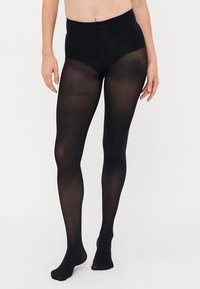 Collant neri opachi con vita alta, texture liscia e senza motivi o accenti visibili, progettati per coprire completamente le gambe.