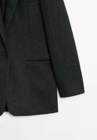 Tumma harmaa villa-blazer, jossa on yksi napin kiinnitys, lovelliset kaulukset ja rintatasku, jolla on sileä pinta.