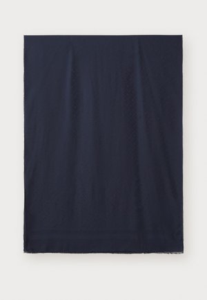Tissu rectangulaire bleu marine foncé avec des motifs diagonaux subtils et des bords à franges sur un fond clair.
