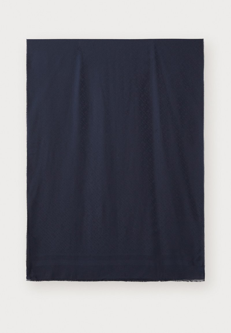 Tissu rectangulaire bleu marine foncé avec des motifs diagonaux subtils et des bords à franges sur un fond clair.