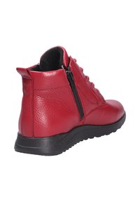 Stivaletto in pelle rossa con superficie testurizzata, lacci frontali e zip laterale. Presenta una suola in gomma nera per aderenza e stabilità.