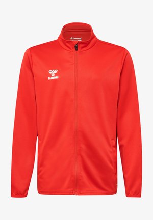 Giacca rossa con zip realizzata in tessuto liscio, caratterizzata da maniche lunghe e colletto alto. Sul fronte è presente un logo bianco con la scritta "hummel."