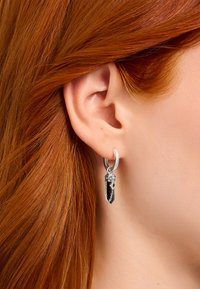 Silver hoop earring with a black crystal pendant, featuring a textured chain detail for added contrast and visual interest.
