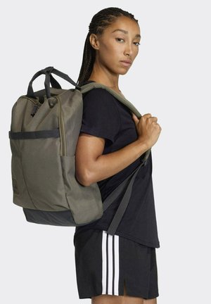 Olive green backpack with a structured design, multi-compartments, adjustable straps, and a durable fabric texture. Black base panel.