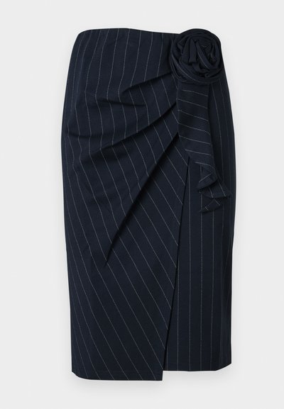 Marineblauwe knielange rok met witte streepjes, wikkeldesign en een stoffen rozetdetail in de taille.