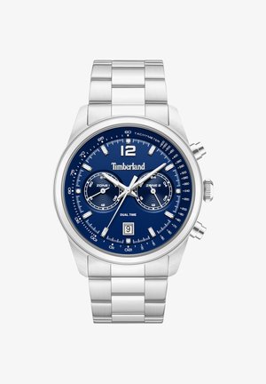 Orologio Timberland in metallo argento con quadrante blu, doppio fuso orario, scala tachimetrica, display della data e tre pulsanti di controllo sul lato.