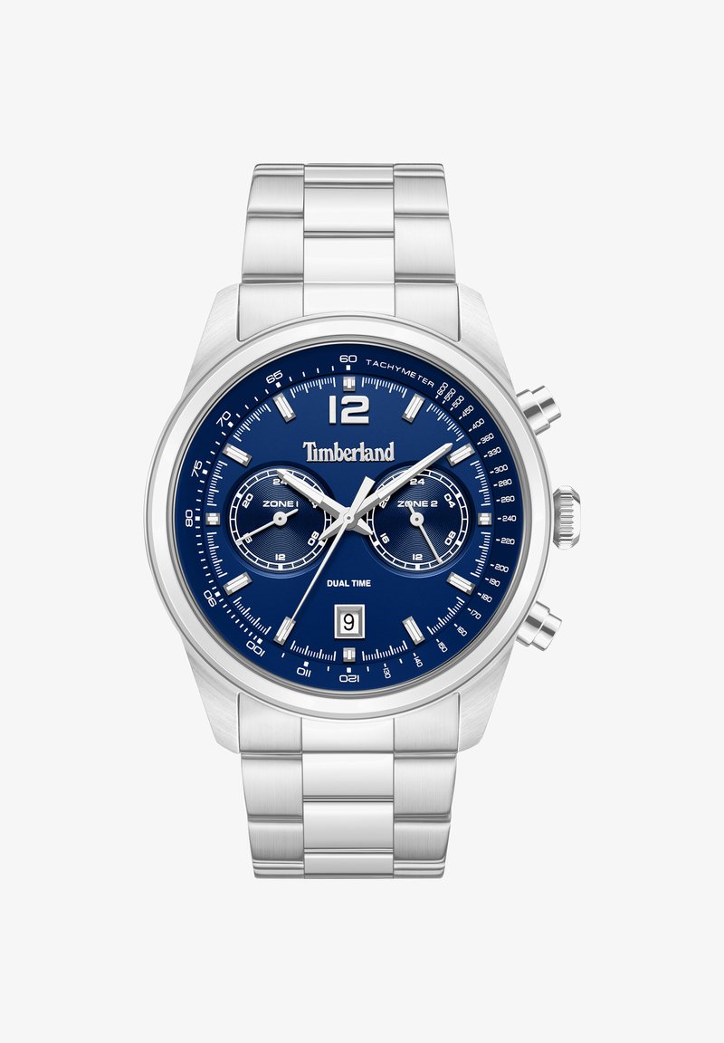 Montre Timberland en métal argenté avec cadran bleu, double fuseau horaire, échelle tachymétrique, affichage de la date et trois boutons de contrôle sur le côté.