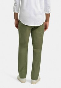 Olivgrön bomullsbukser med rak passform, platt frontdesign och bakfickor, tillsammans med vita sneakers och en vit skjorta.