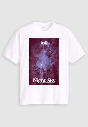 Biely tričko značky Levi’s s grafikou hviezdnej nočnej oblohy pozorovanej cez vysoké stromy a textom "Nočná obloha" a "Levi’s Explorer Division" na prednej strane.