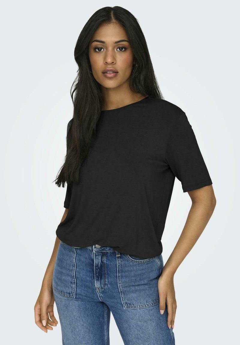 Black cotton t-shirt with short sleeves and a crew neckline, styled relaxed fit, paired with high-waisted blue denim jeans.