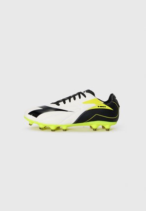 Vita och svarta fotbollsskor med neon gula detaljer och dobbar, sida vy på vit bakgrund.