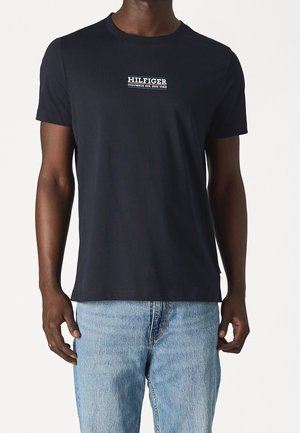 Granatowa bawełniana koszulka z krótkim rękawem, okrągłym dekoltem i białym logo "HILFIGER COLUMBUS AVE. NEW YORK" umieszczonym na środku klatki piersiowej.