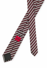 Bordeaux slipsud med hvide striber, der har en ensfarvet sort underside og et rødt mærke med teksten "HUGO." Glat tekstur, klassisk design og standard bredde.