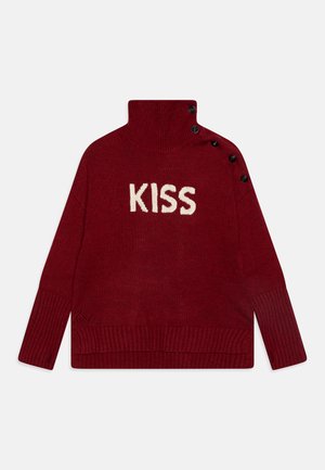 Suéter de punto burdeos con alto cuello, letras "KISS" en crema y acentos de botones negros en el hombro. Puños y dobladillo de canalé.