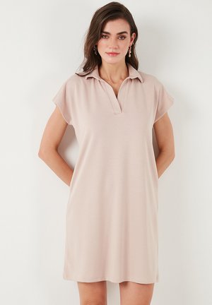 Polo-style dress in light pink fabric with short sleeves and a V-neck. Features a relaxed fit and soft texture, suitable for casual wear.