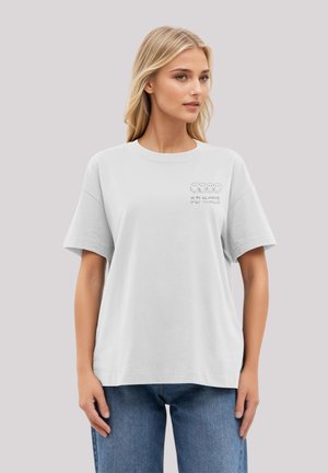White cotton t-shirt with a relaxed fit and short sleeves. Features printed cartoon faces and the text "We are all original" in black.