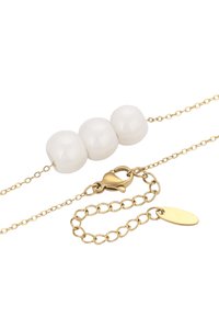 Collana in oro con tre perle bianche lisce posizionate centralmente. Include un gancio a incastro e un'etichetta ovale.