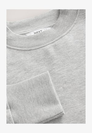 Szara bluza z prążkowanym kołnierzem i mankietami. Miękka tekstura materiału, okrągły dekolt i mała kieszonka z przodu. Widoczna metka marki.