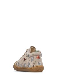 Scarpa per bambino beige con suola marrone, decorata con colorati dinosauri dei cartoni animati, mostrata da un'angolazione laterale posteriore su uno sfondo bianco.