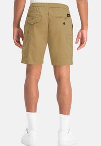 Pantalones cortos cargo color caqui con una cinturilla elástica, múltiples bolsillos y una etiqueta en la parte trasera. Textura suave y diseño hasta la rodilla.