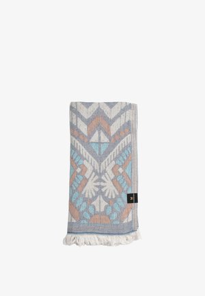 Gevouwen lichtblauw, wit en oranje textiel met geometrische patronen en franjes op een witte achtergrond.