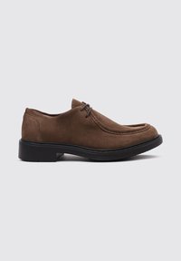 Chaussure oxford en suède marron avec bout arrondi, détails cousus et semelle en caoutchouc noir. Comprend deux œillets pour les lacets.