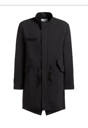 Geacă parka lungă neagră cu guler înalt, buzunare cu clapetă în față, șnururi la talie și o mică etichetă de brand aproape de tiv.