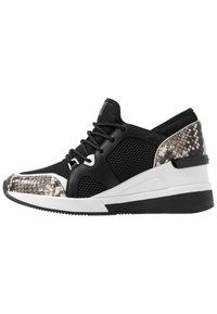 Zapatillas negras con parte superior de malla, acentos en blanco y negro con patrón de reptil texturizado, y una entresuela blanca con una suela negra.