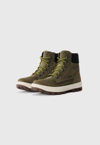 Bottes de randonnée en suede vert olive avec des colliers rembourrés noirs, des lacets jaune-vert, des semelles intermédiaires blanches épaisses et des semelles extérieures robustes brunes.