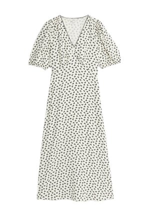 Vestido blanco floral con mangas abullonadas, escote en V y acentos de patrón de hojas negras por todo el diseño. Tejido ligero con un estilo fluido.