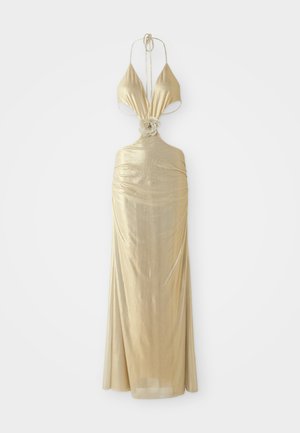 Metallic guld halterklänning med djup urringning, veckad textur och en blommig knutdetalj vid midjan, som flödar ut till en lång kjol.