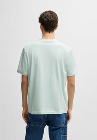 Light green short-sleeve t-shirt with a crew neckline, made of soft fabric. Simple, smooth texture with no visible patterns or embellishments.