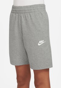 Šedé bavlněné šortky s elastickým pasem a bílým logem Nike na levé straně. Hladká textura, délka ke kolenům, volnočasový design.