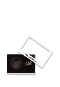 Skórzany pasek z dwiema metalowymi klamrami z logo Karla Lagerfelda w czarnym pudełku prezentowym z białą pokrywą.