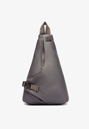 Ciemnoszary trójkątny plecak na jedno ramię z uchwytem na górze, przednią kieszenią na suwak, regulowanym bocznym paskiem i naszywką z logo G-Star Raw.