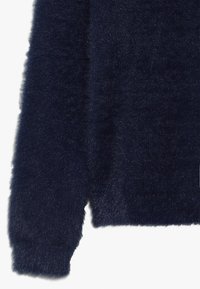 Marineblauer, flauschiger Pullover mit weicher Textur, ausgestattet mit einem Rundhalsausschnitt und langen Ärmeln, dargestellt von der Manschette bis zum Saum.