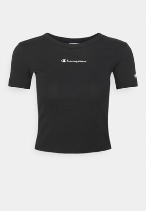 Sort croppet T-shirt med korte ærmer og hvidt "Champion"-logo centreret på brystet samt lille logo på venstre ærme.