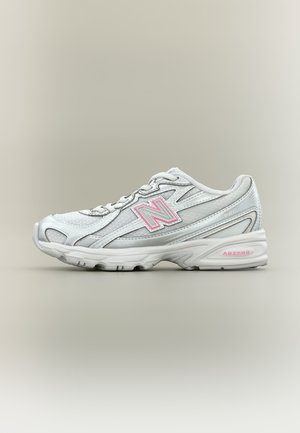 Weißer und grauer Sportschuh mit pinkem "N" Logo und "ABZORB" Schriftzug, nach rechts geneigt auf neutralem Hintergrund.