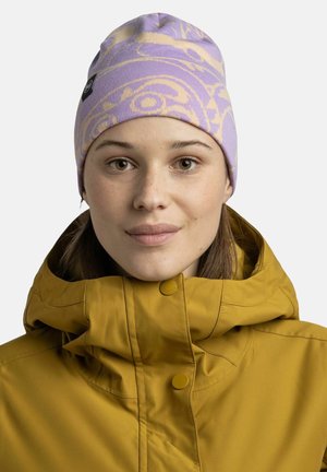 Purple beanie with a light pattern and a logo tag, made from knitted fabric. Worn with a yellow, insulated jacket featuring a stand-up collar.