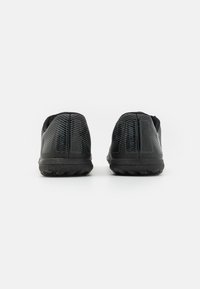 Black athletic shoes with a textured upper and distinct pattern, featuring a rubber outsole designed for traction and durability.