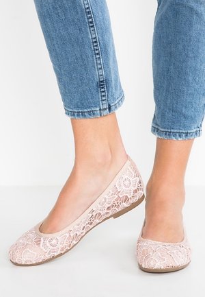 Baleriny z koronką w miękkim różowym odcieniu. Delikatna koronkowa aplikacja w kwiatowy wzór, zaokrąglony nos oraz płaska, teksturowana podeszwa. Noszone z podwiniętymi dżinsami.