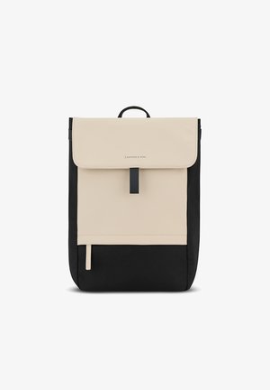 Musta ja beige reppu, jossa on sileä, matta pinta. Varustettu taitettavalla läpällä, keskeisellä hihnasuljennalla ja sivuzipper-taskulla.