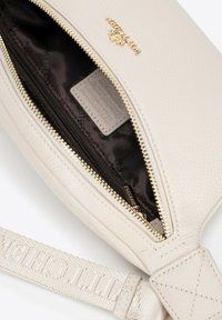 Svetle hnědá kožená taška se zipovým uzavřením, s hladkým povrchem, zlatými kovovými detaily a plátěným popruhem s embosovaným logem.