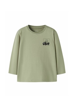 T-shirt manches longues vert clair pour tout-petit avec col rond et petit dinosaure noir conduisant un jeep imprimé sur le côté gauche de la poitrine.