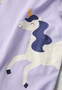 Violetti puuvillakangas, jossa on leikkisä yksisarvissuunnittelu. Yksisarvisella on kultainen sarvi, virtaava tummansininen harja ja mustat kaviot.