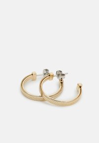 Pendientes de aro en tono dorado que presentan un diseño texturizado trenzado y acentos de perlas cuadradas. Incluyen un pestillo y una clavija en tono plateado para el cierre.