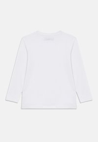 Λευκό μακρυμάνικο μπλουζάκι από βαμβάκι. Διαθέτει στρογγυλή λαιμόκοψη και ίσια ραφή στο τελείωμα. Ετικέτα μπλε στο πίσω μέρος κοντά στον λαιμό. Χωρίς σχέδια ή γραφικά.