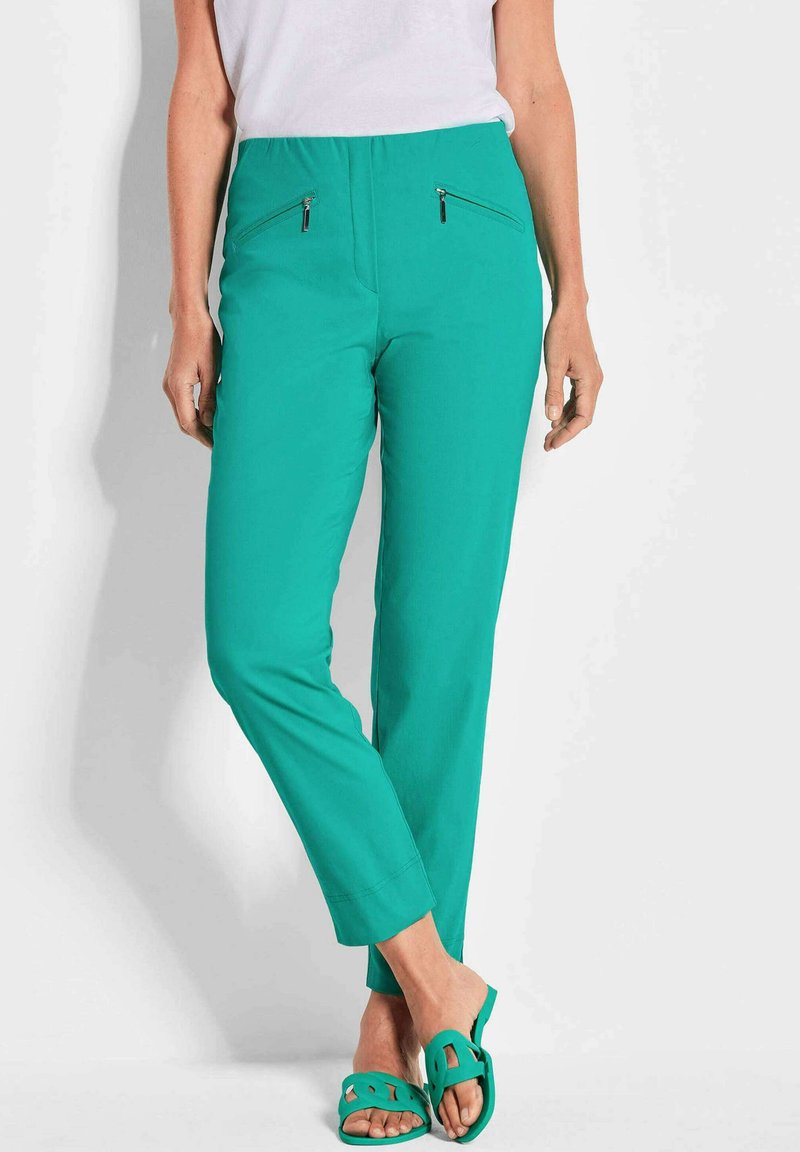 Pantalons teal avec une texture lisse, dotés de deux poches zippées à l'avant, d'une coupe fuselée et d'une taille confortable.